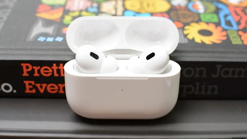 Some earbuds in a case in front of a book.