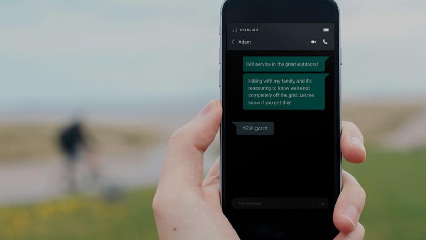 A person holds up a phone with text messages sent via Starlink's satellite network.