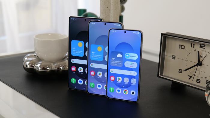The Samsung Galaxy S25, Galaxy S25+ and Galaxy S25 Ultra stand in a row on a black tabletop.