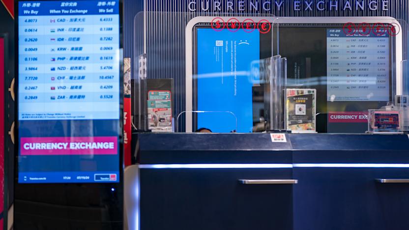 HONG KONG, CHINA - JULY 19: A error blue screen is displayed at a currency exchange store at the Hong Kong International Airport on July 19, 2024 in Hong Kong, China. A significant Microsoft outage impacted users globally, leading to widespread disruptions, including cancelled flights and disruptions at retailers globally. Airlines like American Airlines and Southwest Airlines reported difficulties with their systems, which rely on Microsoft services for operations. The outage affected check-in processes and other essential functions, causing frustration among travellers and lines to back up at many affected airports worldwide. (Photo by Anthony Kwan/Getty Images)