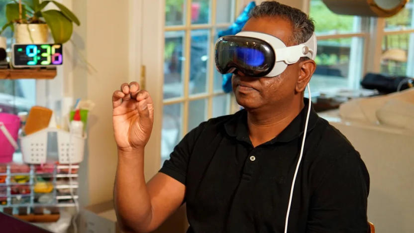Engadget editor Devindra Hardawar wears the Apple Vision Pro headset and makes a pinching gesture with his hand 