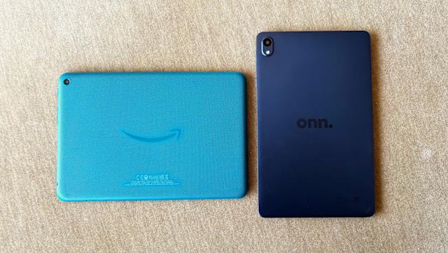 The teal blue Amazon Fire HD 8 and navy blue Walmart Onn 8" tablets rest face down on a light brown couch cushion.