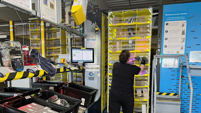 An Amazon worker places a product on a shelf for storage, at an Amazon warehouse, which opened in August 2021, in Dartford, Kent, Britain May 3, 2023. REUTERS/Helen Reid