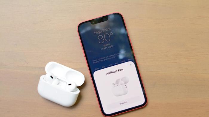 A pair of 2nd Gen AirPods Pro next to an iPhone.