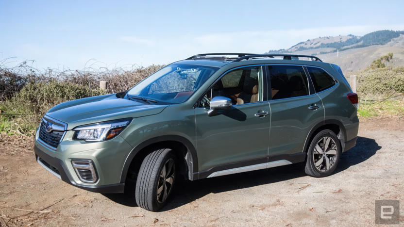 A Subaru Forester sitting on a dirt road in front of a desert vista.