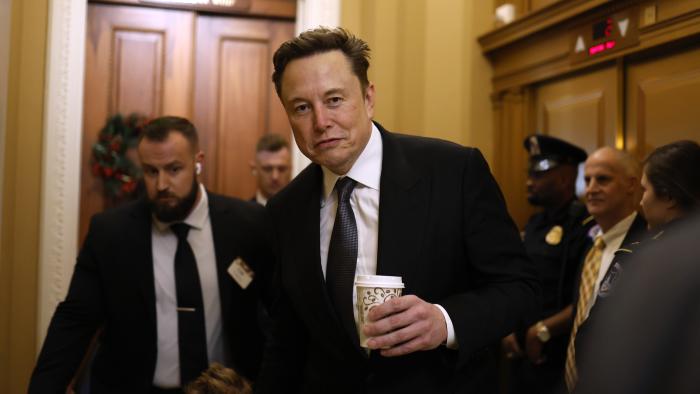 WASHINGTON, DC - DECEMBER 05: Tesla CEO Elon Musk, Co-Chair of the newly announced Department of Government Efficiency (DOGE), arrives on Capitol Hill with his son on December 05, 2024 in Washington, DC. Musk and his Co-Chair, businessman Vivek Ramaswamy are meeting with lawmakers today about DOGE, a planned presidential advisory commission with the goal of cutting government spending and increasing efficiency in the federal workforce. (Photo by Anna Moneymaker/Getty Images)