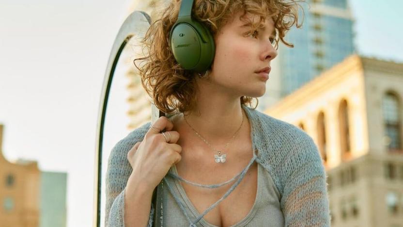 A person wears green Bose headphones.