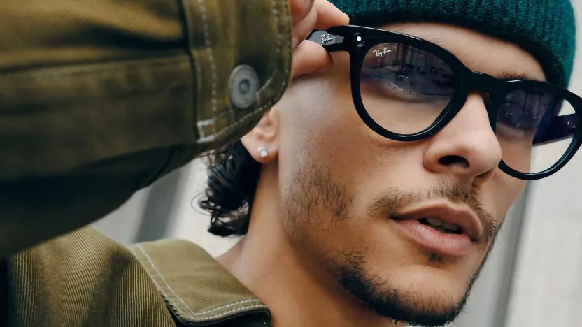 Someone adjusting a pair of black Ray-Ban Meta Smart Glasses on their face.