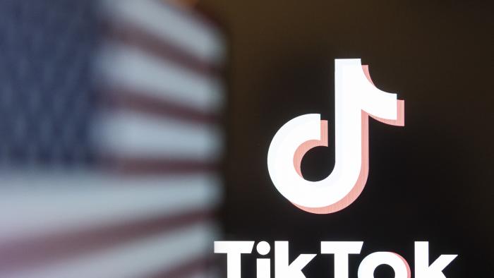 Photo illustration of TikTok app logo on a smartphone screen displayed with the American flag (USA). Amsterdam, the Netherlands on January 2025 (Photo by Nicolas Economou/NurPhoto via Getty Images)