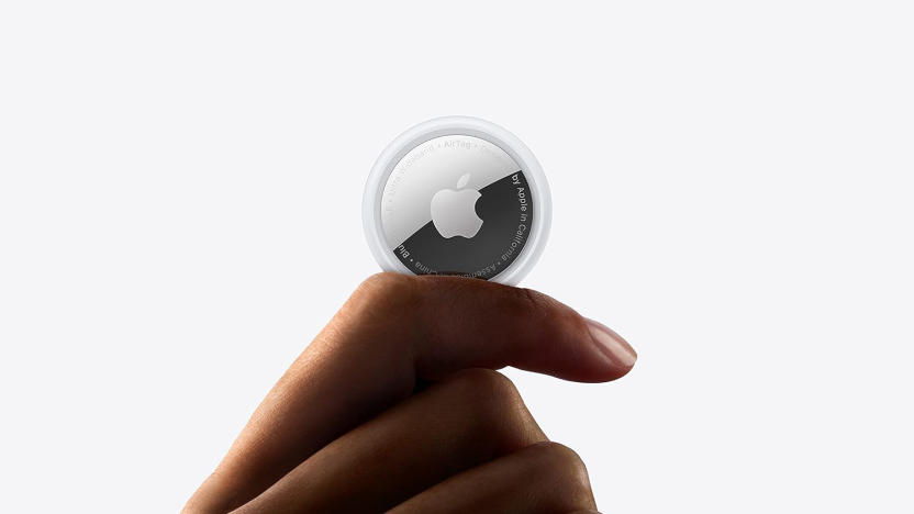A hand holding a round, coin-sized device with the Apple logo.