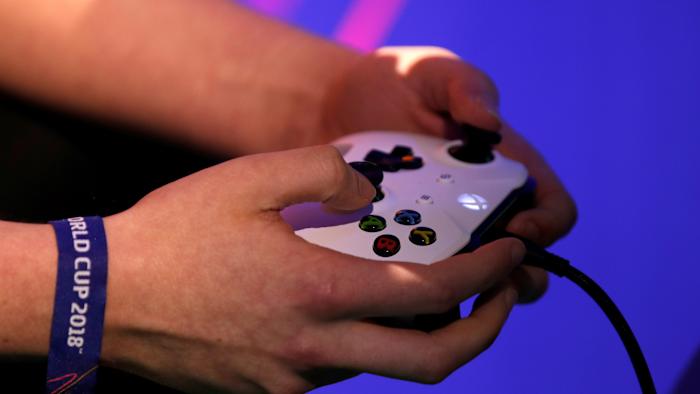 A player holds his gaming controller as he  competes in the FIFA 2018 eClub World Cup qualifiers in Paris, France, May 19, 2018. REUTERS/Philippe Wojazer