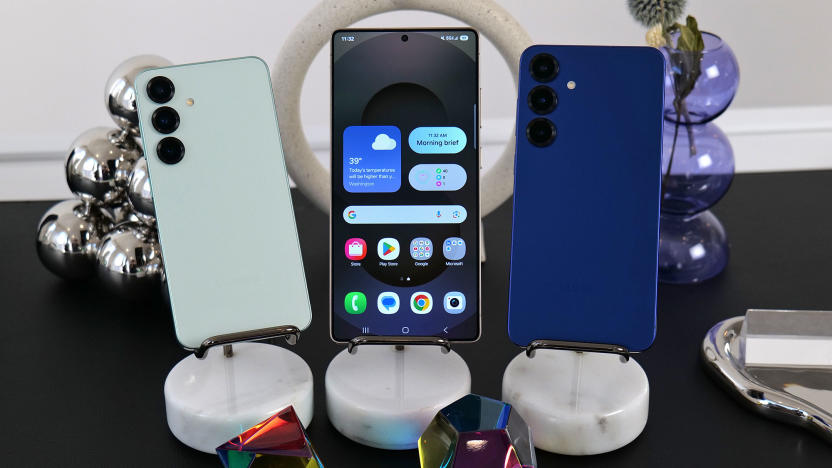 The Samsung Galaxy S25 lineup is displayed on a table with shiny baubles on it. The Galaxy S25, S25+ and S25 Ultra are shown. 