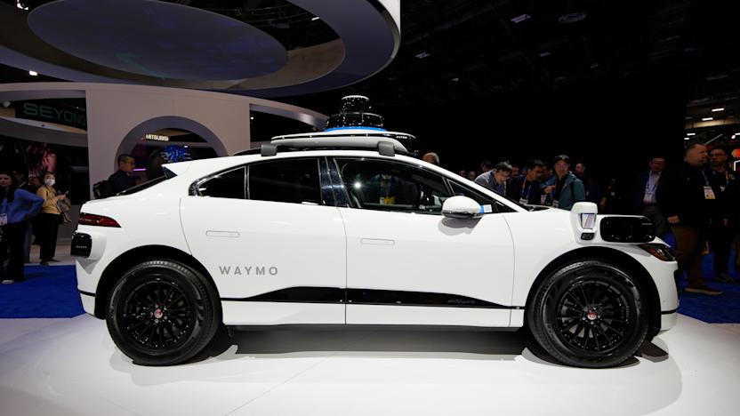 People look at a Jaguar I-Pace with 5th Generation Waymo Driver on display at the Waymo booth during the CES tech show Tuesday, Jan. 7, 2025, in Las Vegas. (AP Photo/John Locher)