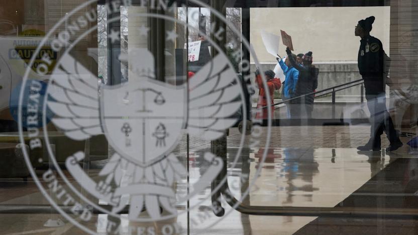 FILE PHOTO: A special police member monitors a protest, while inside the Consumer Financial Protection Bureau (CFPB) building, the day after members of Elon Musk's Department of Government Efficiency (DOGE) moved into the CFPB, in Washington, U.S. February 8, 2025. REUTERS/Nathan Howard/File Photo