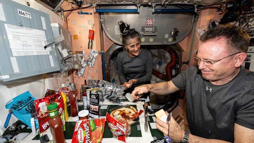 FILE - In this photo released by NASA, astronauts Suni Williams and Butch Wilmore, both Expedition 71 Flight Engineers, make pizza aboard the International Space Station's galley located inside the Unity module on Sept. 9, 2024. Items are attached to the galley using tape and velcro to keep them from flying away in the microgravity environment. (NASA via AP, File)