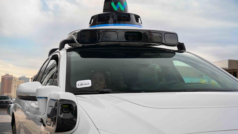 A Waymo robotaxi with an Uber sticker on it.