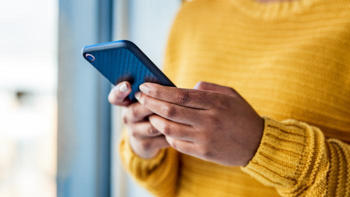 Shot of an unrecognizable woman using a mobile phone indoors